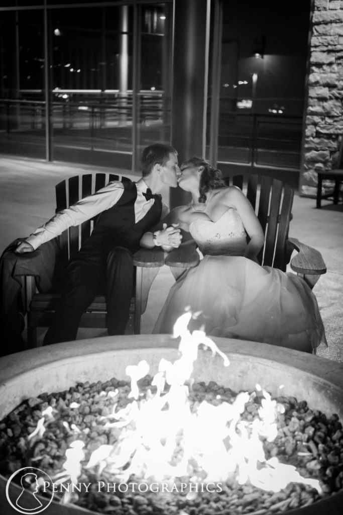 bride and groom kissing by the fire pit outside Pinstripes Minneapolis