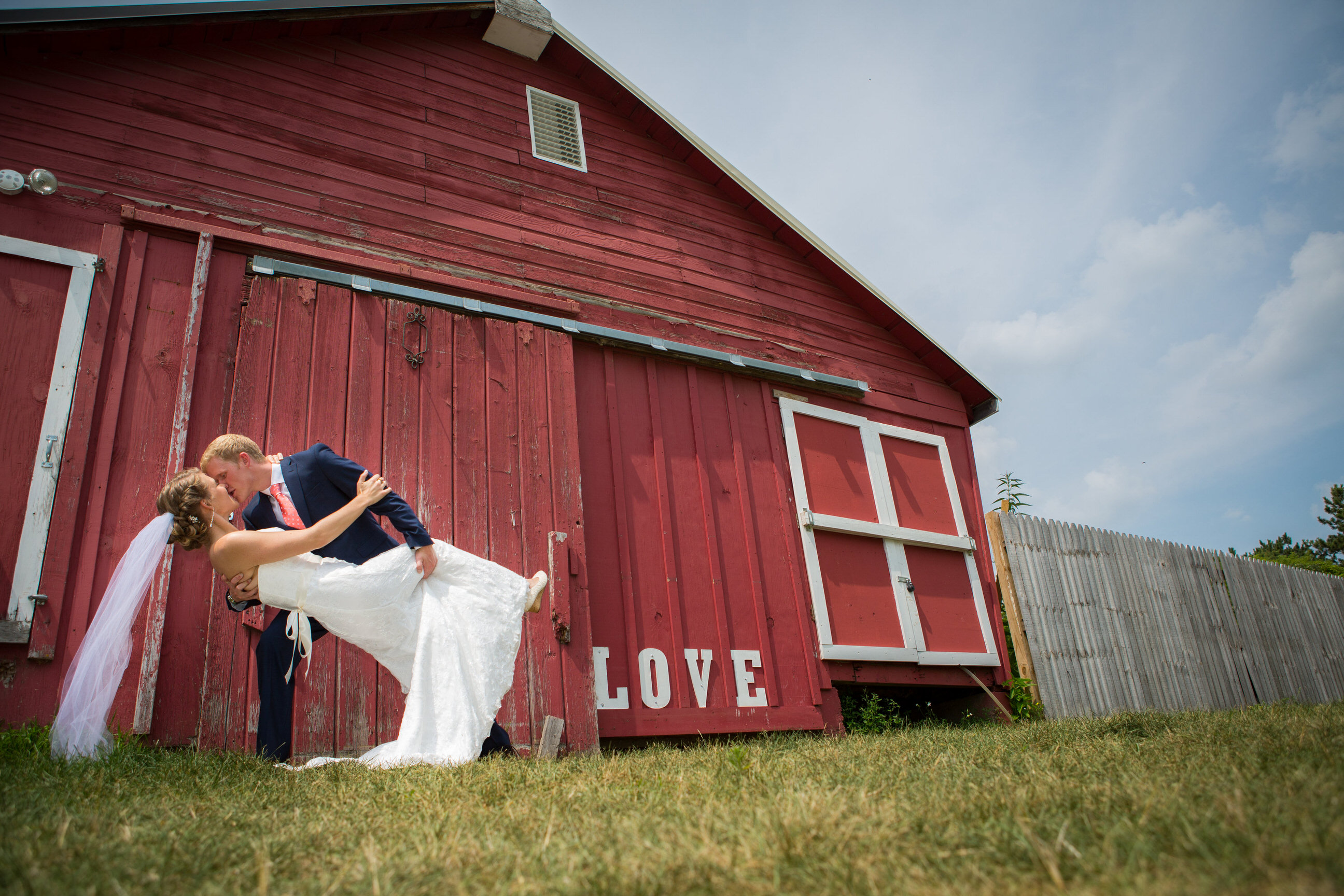 Bride and Groom dip in front of barn