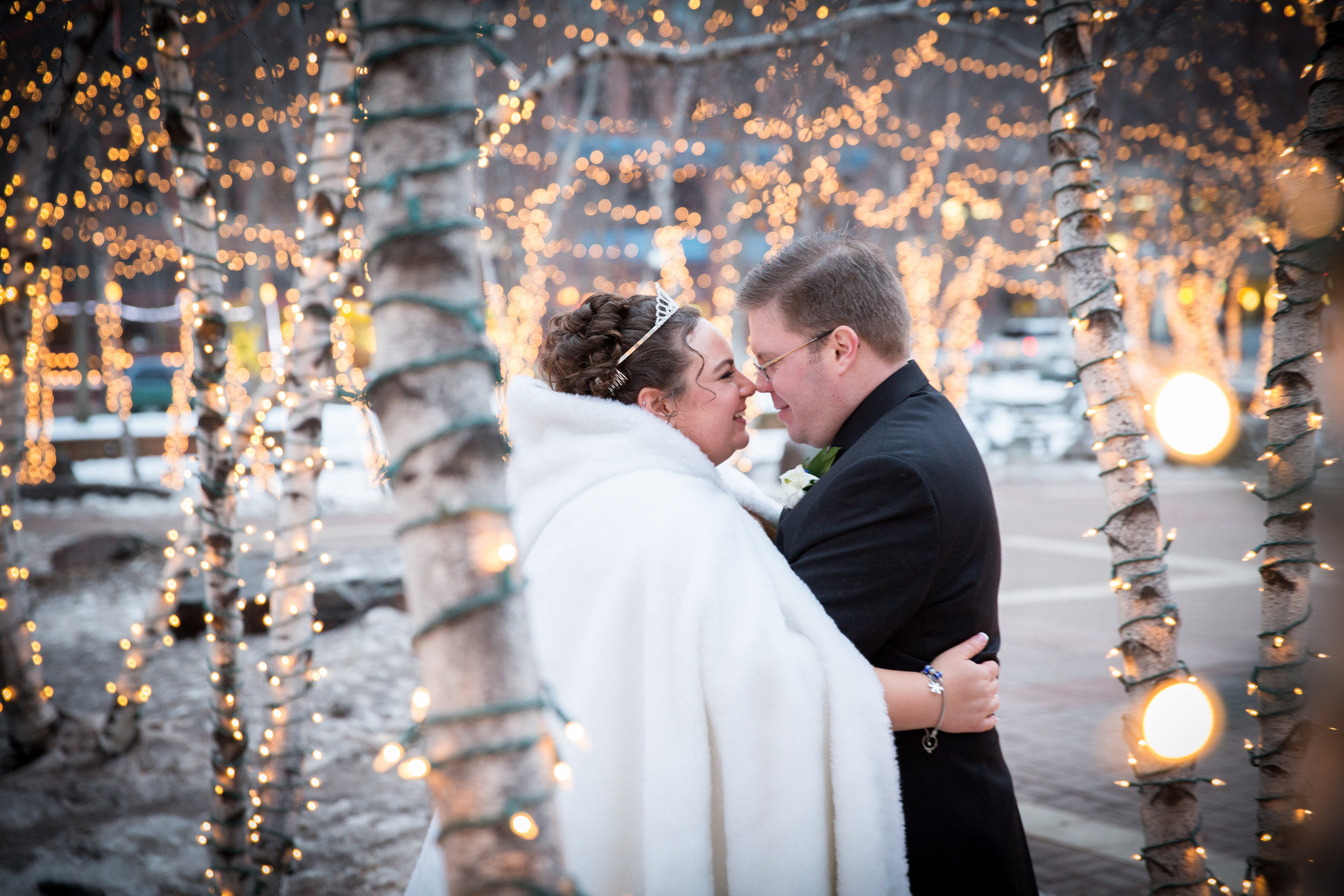 Bride and Groom in snow under Christmas lights