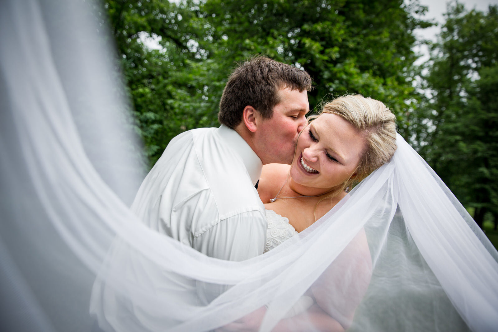 Lakeside Glenwood Wedding couple kiss under veil