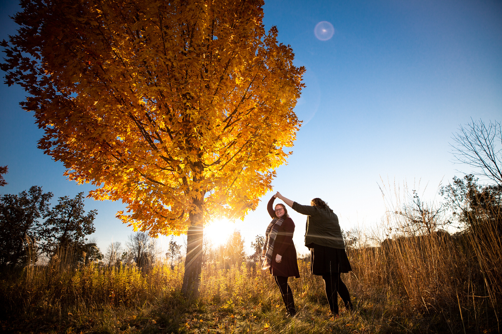 Park Engagement Session couple spinning under fall leaves