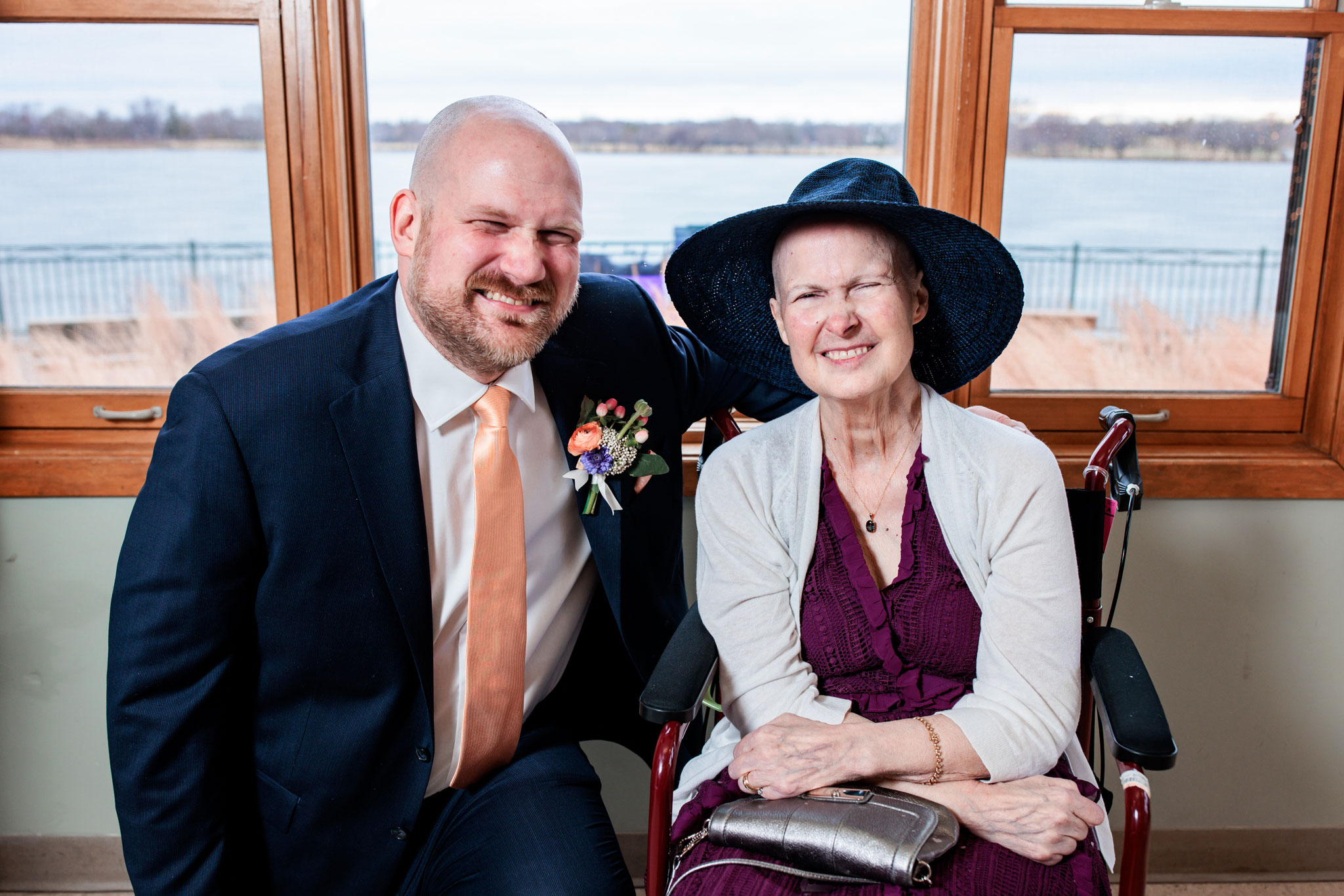 A groom and his mother smile the same smile during family formal photos in Minneapolis.