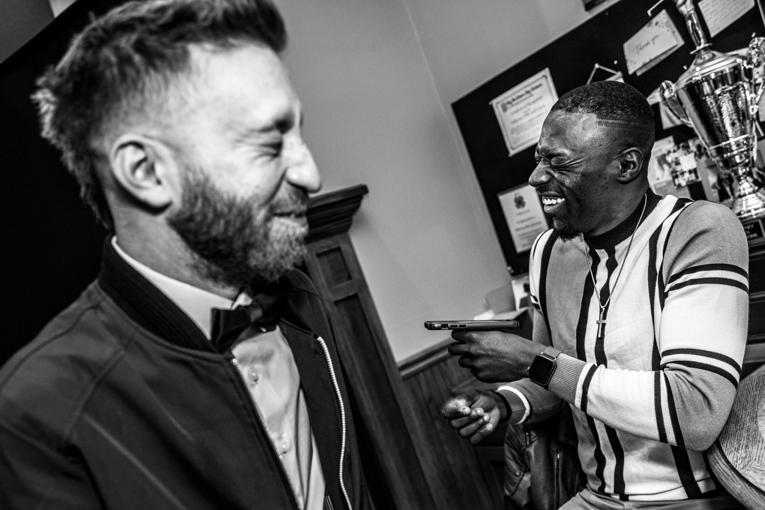 Two men laughing so hard their eyes are closed.