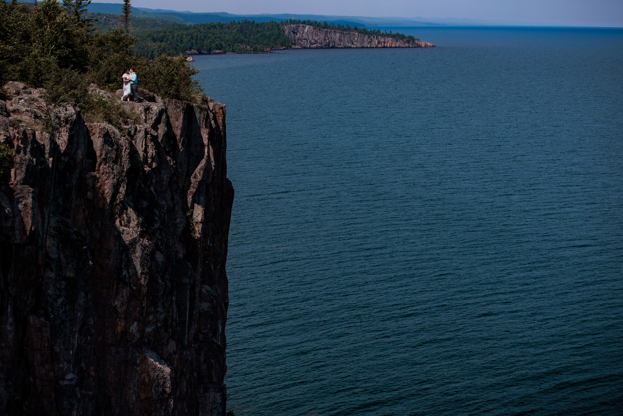 Engaged couple standing on cliff of Palisade head in Two Harbors, MN.