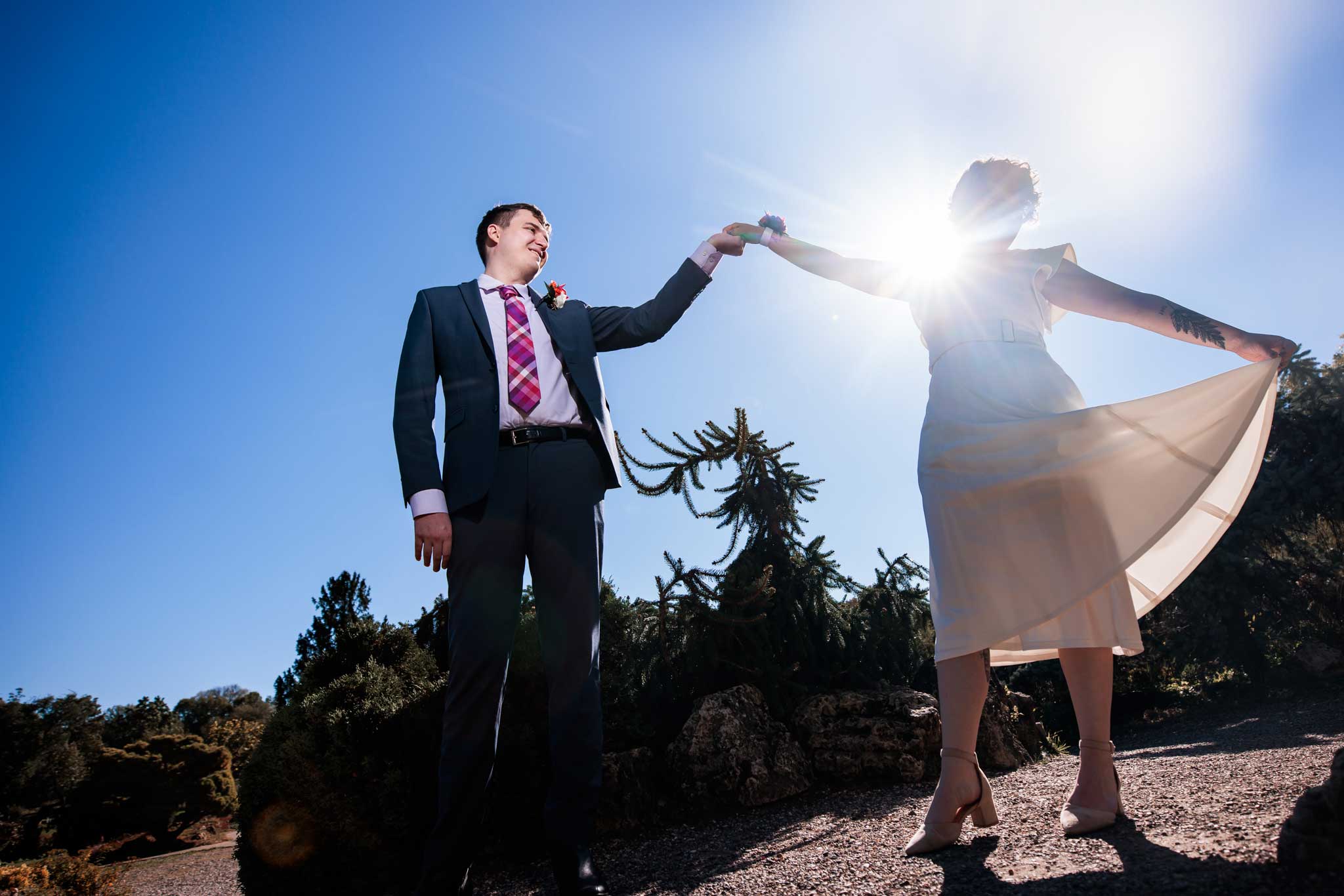 A bride and groom dancing in the bright sunshine in the Lyndale peace garden.