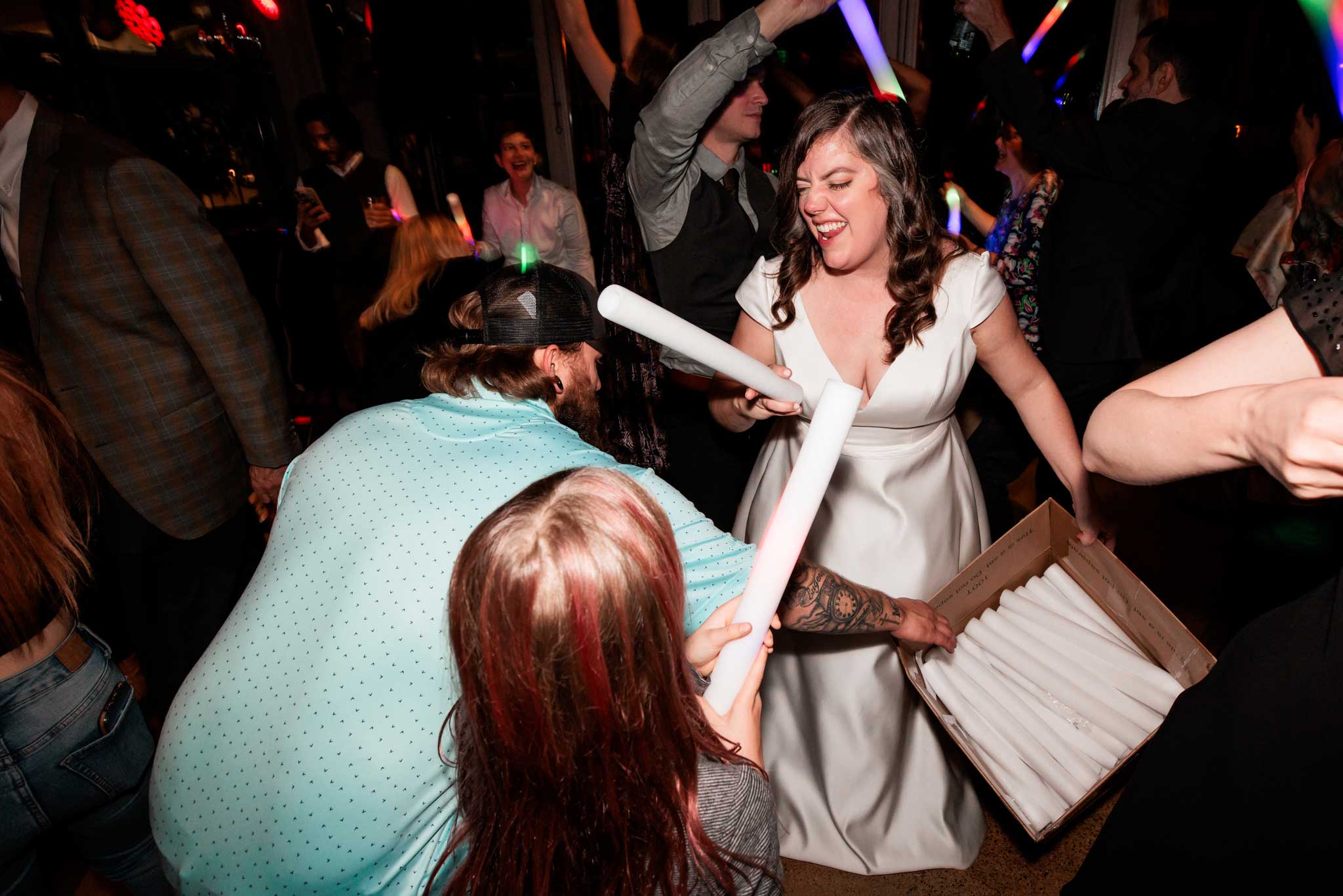 A bride playing with light wands on reception floor.