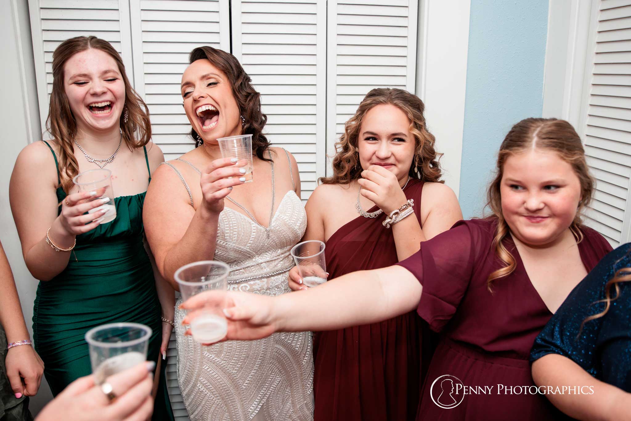 A bride and her bridesmaids laughing and cheering. 