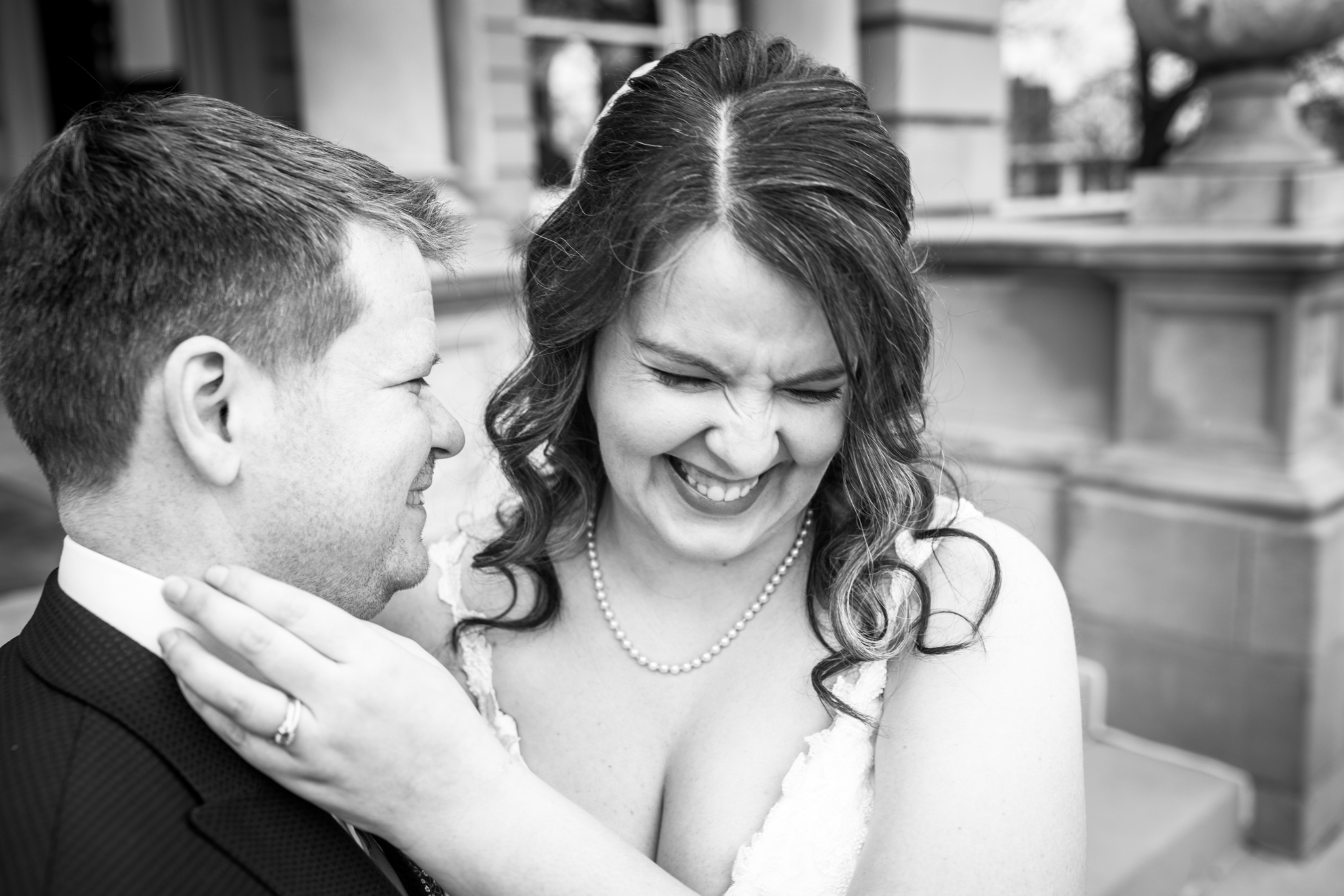 A bride laughing with her groom outside.