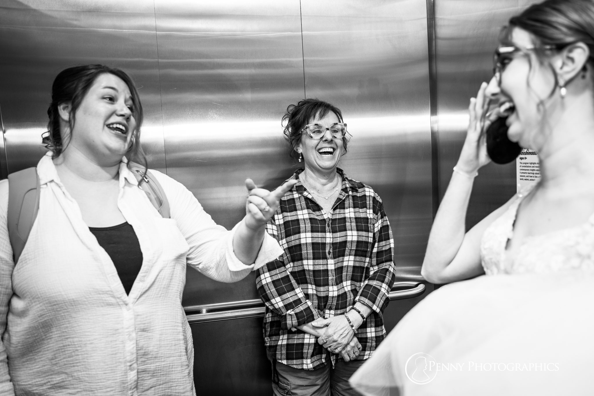 Candid shot of bride with her maid of honor and her mother laughing.